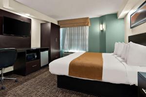 um quarto de hotel com uma cama grande e uma secretária em Quality Inn Memphis Northeast near I-40 em Memphis