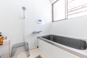 um lavatório numa casa de banho branca com uma janela em KANJYAKU-AN - Vacation STAY 76347v em Nakatsugawa