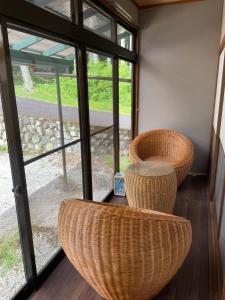 um quarto com duas cadeiras de vime e uma mesa em KANJYAKU-AN - Vacation STAY 76347v em Nakatsugawa