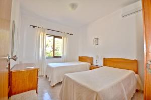 um quarto de hotel com duas camas e uma janela em Close to amenities, free air conditioning and wi-fi em Quarteira