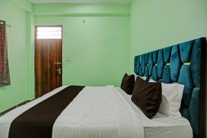 une chambre avec un grand lit et une tête de lit bleue dans l'établissement OYO J M K Hotel, à Gurgaon