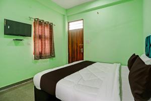 - une chambre avec un grand lit dans une pièce verte dans l'établissement OYO J M K Hotel, à Gurgaon