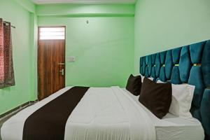 - une chambre avec un grand lit blanc et une tête de lit bleue dans l'établissement OYO J M K Hotel, à Gurgaon