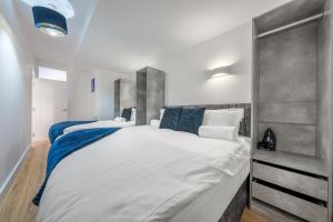 a bedroom with a large white bed with blue pillows at Modern Stylish 2 bedroom apartment in the heart of Potters Bar in Potters Bar