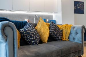 eine Couch mit vielen Kissen drauf in der Unterkunft Modern Stylish 2 bedroom apartment in the heart of Potters Bar in Potters Bar