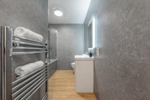 Modern Stylish 2 bedroom apartment in the heart of Potters Bar في بوتيرز بار: حمام مع مرحاض ومغسلة مع مناشف