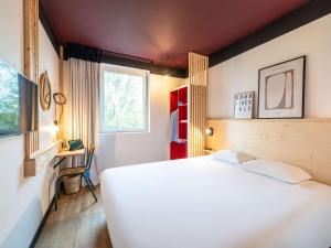 Greet hotel Bourg-en-Bresse Sud Montagnat في Montagnat: غرفة نوم بسرير ابيض كبير ونافذة