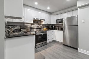 a kitchen with white cabinets and a stainless steel refrigerator at Luxurious and spacious 3 bedroom apartment in Mississauga