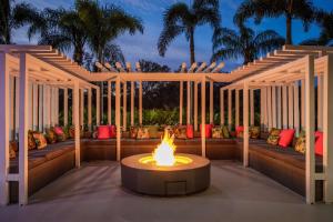 patio meublé avec un foyer extérieur, des canapés et des palmiers dans l'établissement DoubleTree by Hilton Sarasota Bradenton Airport, à Sarasota