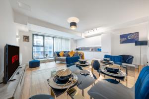 un soggiorno con sedie blu e TV di Modern Stylish 2 bedroom apartment in the heart of Potters Bar a Potters Bar