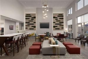 a waiting room with a couch and tables and chairs at Hampton Inn & Suites Durham University Medical Center in Durham