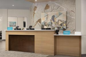 a lobby with a reception desk with a large painting at Hampton Inn & Suites Durham University Medical Center in Durham +34 photos