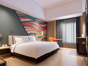 מיטה או מיטות בחדר ב-ibis Styles Serpong BSD City