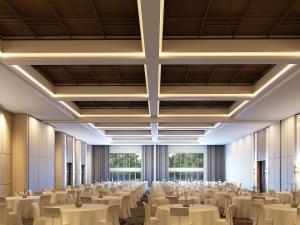 une grande salle de banquet avec des tables et des chaises blanches dans l'établissement ibis Styles Serpong BSD City, à Tangerang