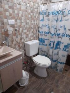 a bathroom with a toilet and a shower curtain at Challao Dream in El Challao