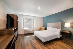 a bedroom with a bed and a flat screen tv at WoodSpring Suites Rockledge - Cocoa Beach in Rockledge