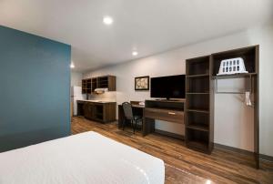 Habitación con cama y escritorio con ordenador. en WoodSpring Suites Rockledge - Cocoa Beach en Rockledge
