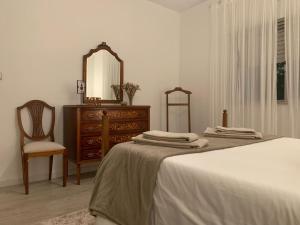 1 dormitorio con cama, tocador y espejo en Cantinho da Rosa - Terras de Bouro en Terras de Bouro