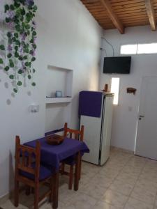 Una cocina con mesa y sillas y un refrigerador. en Violeta Monoambiente, en Salta