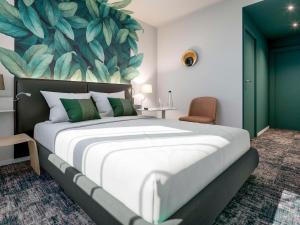 a bedroom with a large bed with a large leaf mural at ibis Styles Bezons Paris La Défense in Bezons