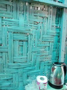 a room with a blue wooden wall with a coffee pot at The Rock Hut in Ko Lanta