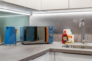 a microwave sitting on a kitchen counter next to a sink at Modern Stylish 1 bedroom apartment in the heart of Potters Bar in Potters Bar