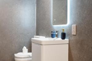 La salle de bains est pourvue d'un lavabo blanc et d'un miroir. dans l'établissement Modern Stylish 1 bedroom apartment in the heart of Potters Bar, à Potters Bar