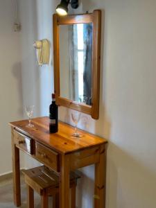 a wooden table with two glasses and a bottle of wine at Kavos Panorama Complex in Kavos