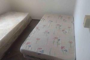 a bed in a room with a sheet with flowers on it at Vacations House in Penonomé, Cocle in Penonomé
