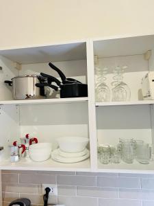 a kitchen cabinet filled with bowls and dishes at Il cretto bianco in Città di Castello
