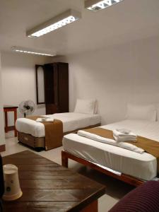 um quarto de hotel com duas camas e uma mesa em Skyland Garden Hotel and Resort em Baguio