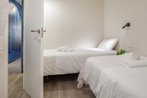 a bedroom with a white bed and white walls at Habitat Apartments Cool Jazz in Barcelona