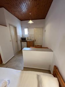 uma cozinha com um balcão branco num quarto em Kavos Panorama Complex em Kavos