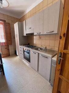 uma cozinha com um lavatório e um fogão forno superior em Gallipoli Il mare in una stanza em Lido Conchiglia