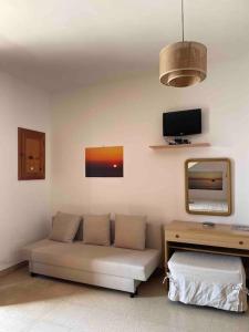 uma sala de estar com um sofá e um espelho em Gallipoli Il mare in una stanza em Lido Conchiglia