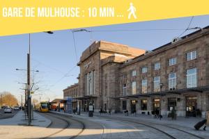 żółty pociąg na ulicy obok budynku w obiekcie Le Tonneliers - bel appartement au centre Mulhouse w Miluzie