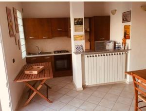 a small kitchen with a table and a microwave at Bella Vista Poggi - 180 Grad fantastischer Meerblick & Pool in Poggi