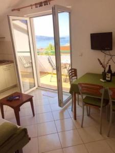 Sala de estar con mesa y vistas al océano en Apartments Šara - free parking, en Primošten