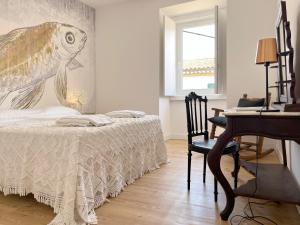 1 dormitorio con 1 cama con una pintura de un pez en la pared en Casa Alta, en Castelo de Vide