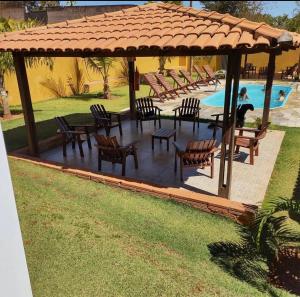 a pavilion with chairs and a table and a pool at Pousada Panela De Ferro in Mateiros