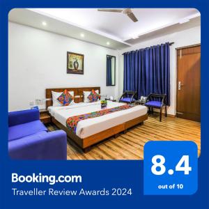 una camera d'albergo con un letto e un divano blu di FabHotel The Residency DLF Galleria a Gurgaon
