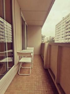 a balcony with chairs and a table and a window at T3 Villeurbanne avec balcon in Villeurbanne