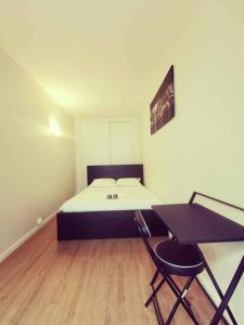 a bedroom with a bed and a desk and a table at T3 Villeurbanne avec balcon in Villeurbanne