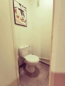 a bathroom with a toilet and a picture on the wall at T3 Villeurbanne avec balcon in Villeurbanne