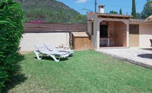 a patio with two chairs and a table in a yard at Villa Can Bolloy Mallorca by PriorityVillas in Llucmajor