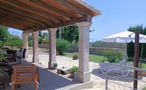 a pavilion with a table and an umbrella at Villa Can Bolloy Mallorca in Llucmajor