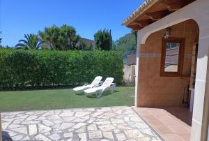 two white chairs sitting on the grass in a yard at Villa Can Bolloy Mallorca by PriorityVillas in Llucmajor +15 photos
