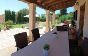 a wooden table and chairs on a patio at Villa Can Bolloy Mallorca in Llucmajor