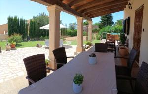 a wooden table and chairs on a patio at Villa Can Bolloy Mallorca by PriorityVillas in Llucmajor