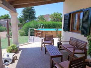 a patio with benches and a swimming pool at Villa Can Bolloy Mallorca in Llucmajor